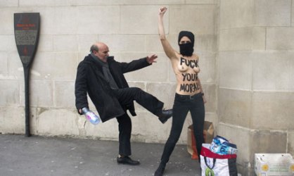 A man kicks a topless Femen activist in Paris